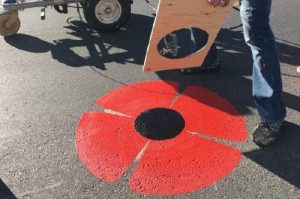 Decorative road marking. A poppy with red petals and a black center for remembrance day.
